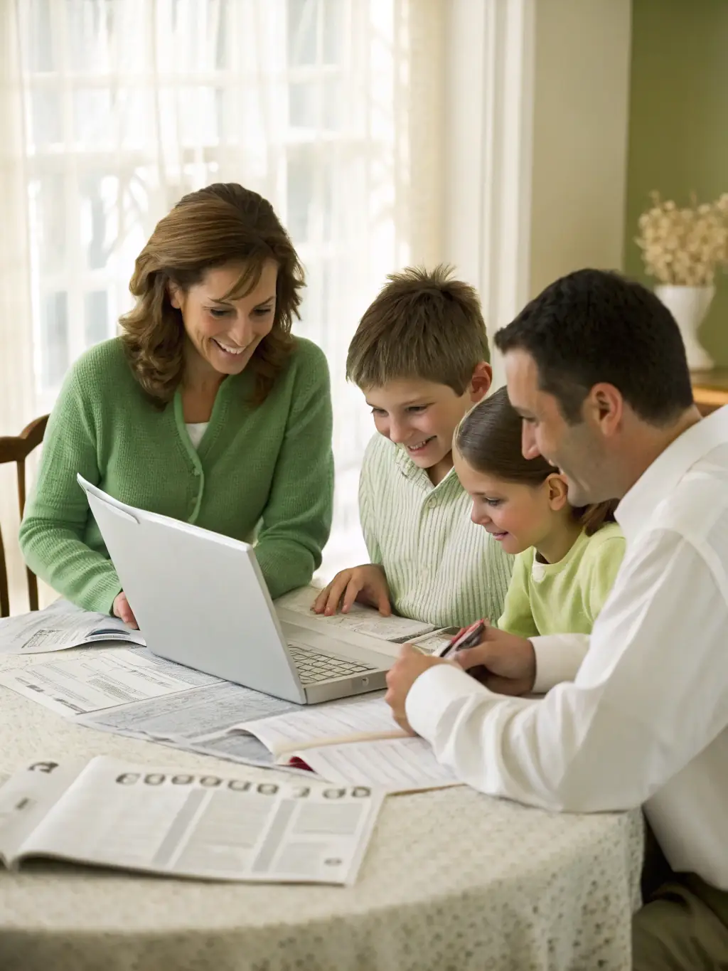 A family happily gathered around a table, reviewing financial documents with a trusted advisor in a well-lit, comfortable home setting.